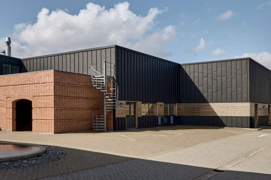 Black steel profiles and warm wood create striking contrasts on headquarters facade, Jernvej 19, 6900 Skjern, Denmark